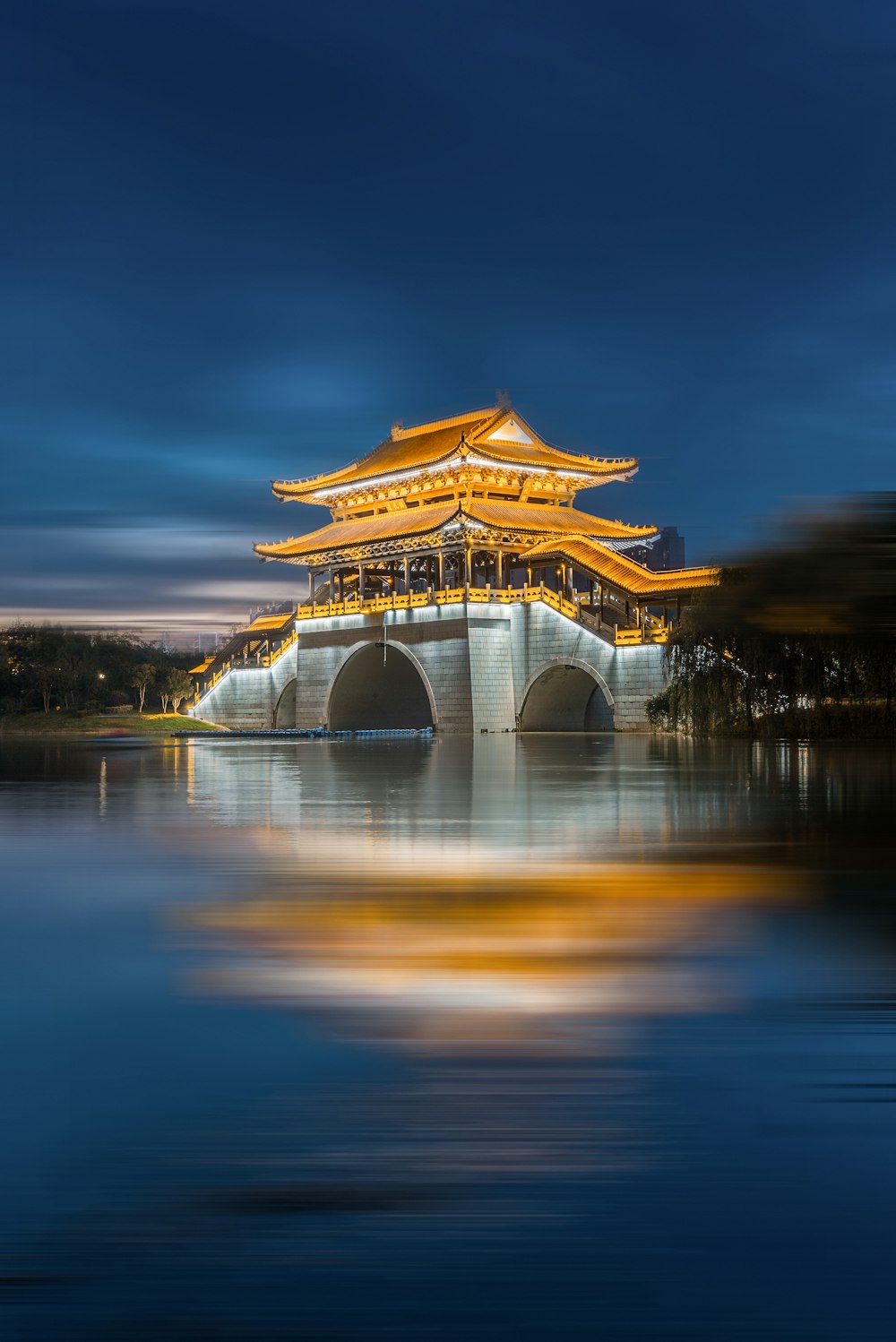 夜間の水域近くの茶色と白のコンクリートの建物