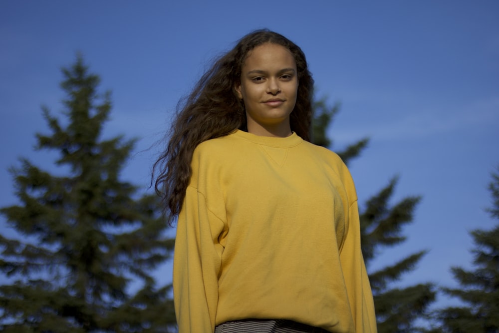 woman in yellow turtleneck sweater standing under blue sky during daytime