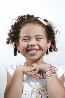 A cheerful child wearing a bright scrunchie in her hair.