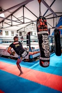 woman in black and white shirt and black shorts standing on black and red boxing gloves