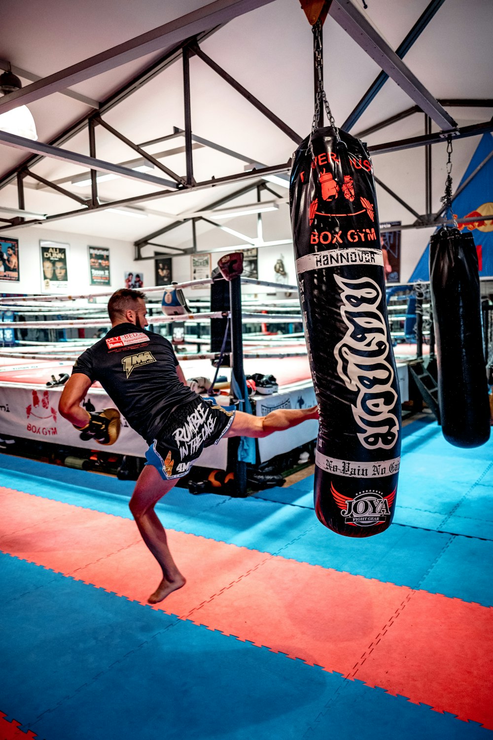 woman in black and white shirt and black shorts standing on black and red boxing gloves