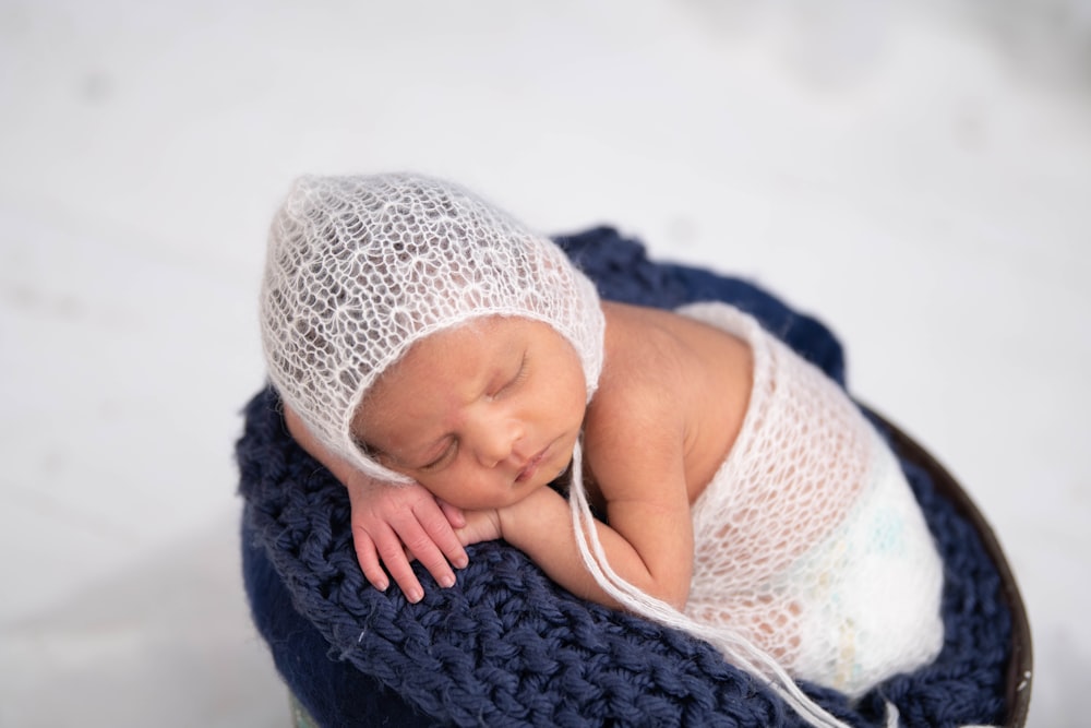 baby in white knit cap and knit cap