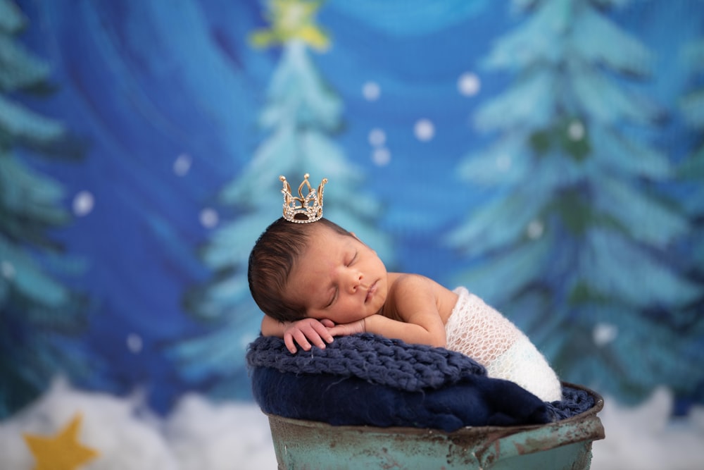 baby in white dress lying on brown rock