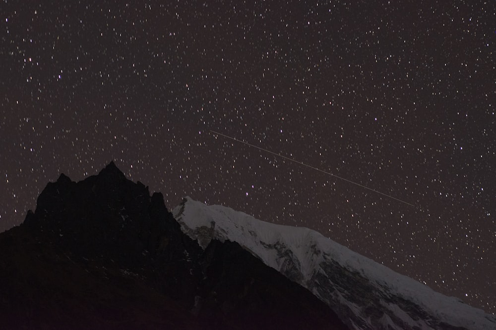 snow covered mountain under clear sky during night time