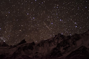 snow covered mountain under starry night