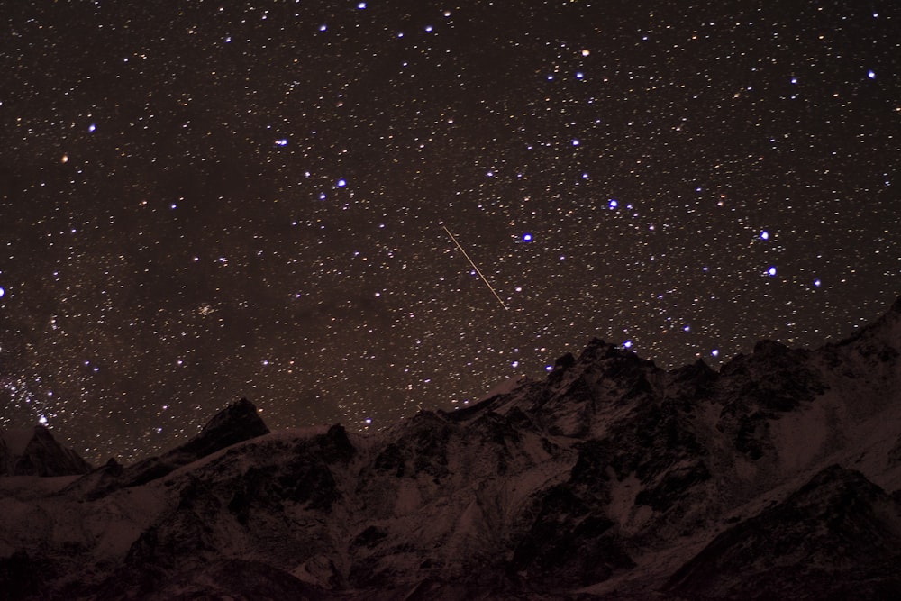 snow covered mountain under starry night