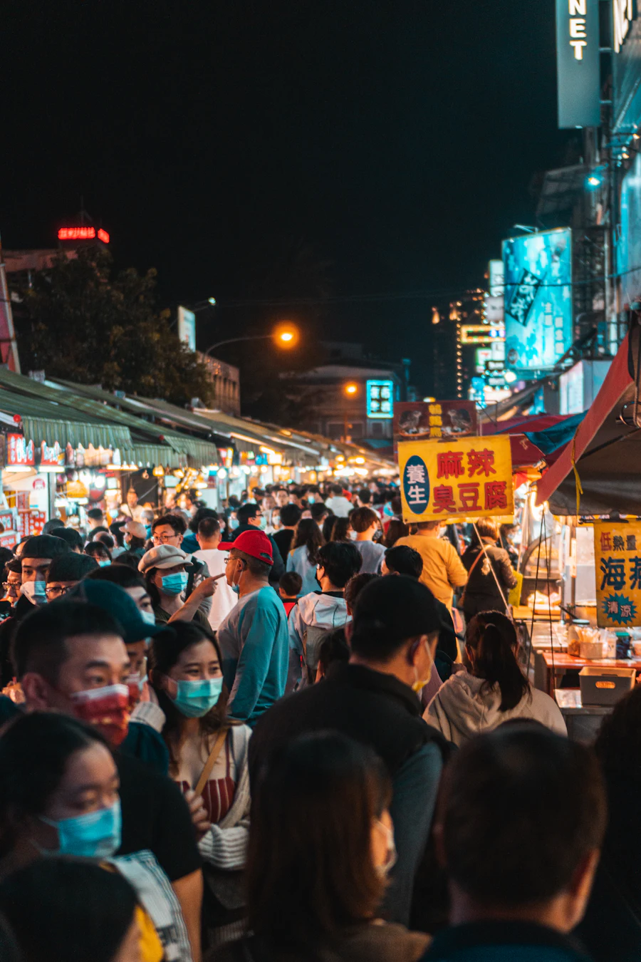 Belebter Nachtmarkt in Taiwan mit Essensständen und Leuchtschildern