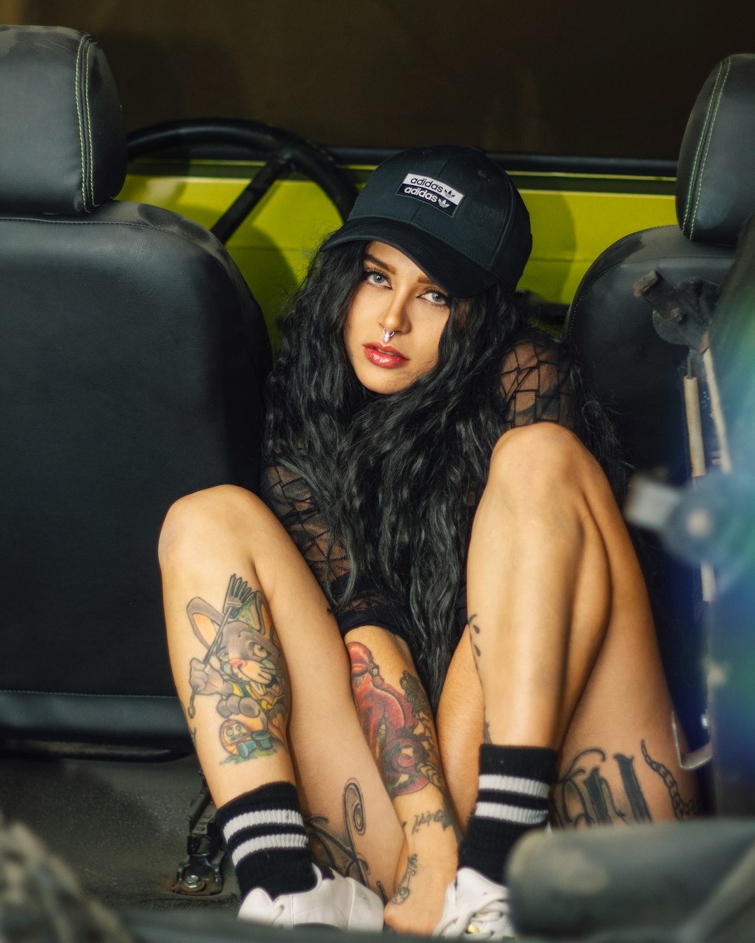woman in black tank top and black shorts sitting on black leather car seat