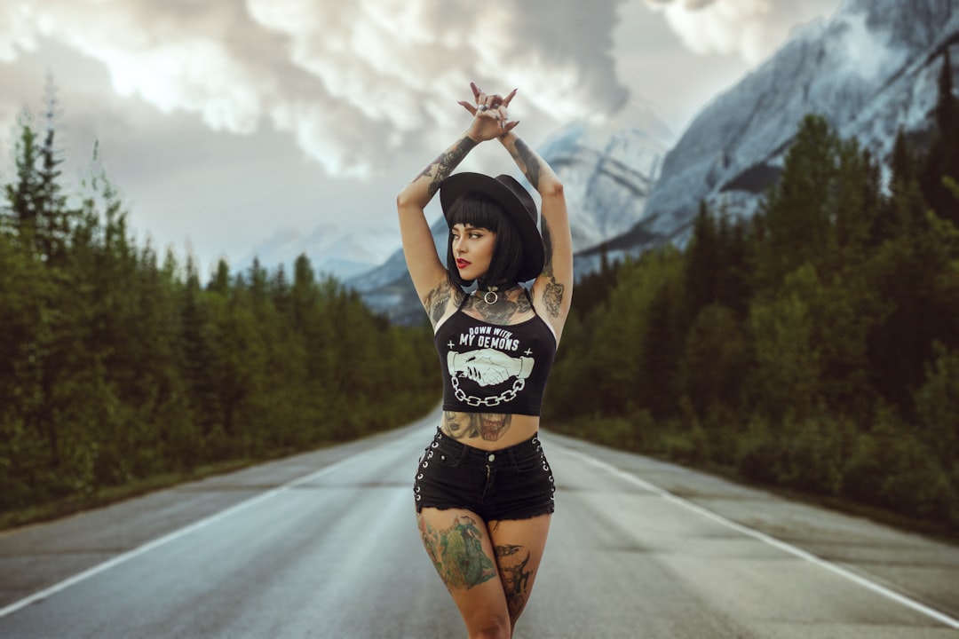 woman in black tank top and black shorts standing on road during daytime