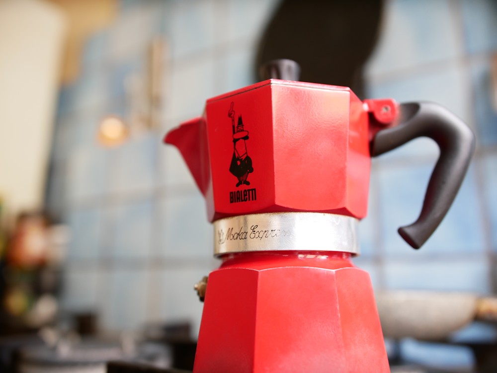 red coffee maker on brown wooden table