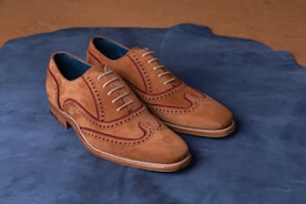 brown leather shoes on blue textile