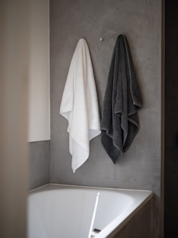 white bath towel on white ceramic bathtub