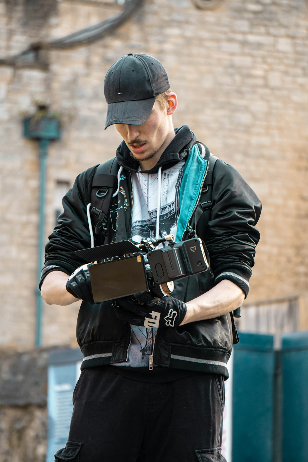 man in black leather jacket holding black smartphone