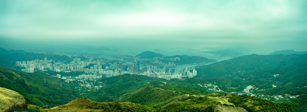 aerial view of city buildings on green mountain during daytime