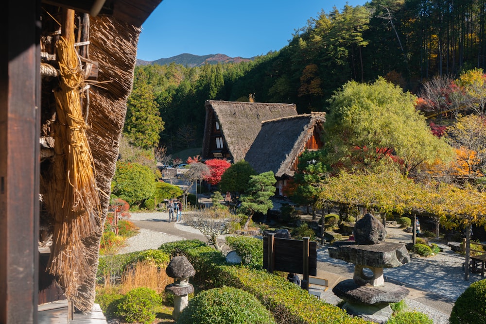 Braunes Holzhaus in der Nähe von grünen Bäumen und Pflanzen tagsüber