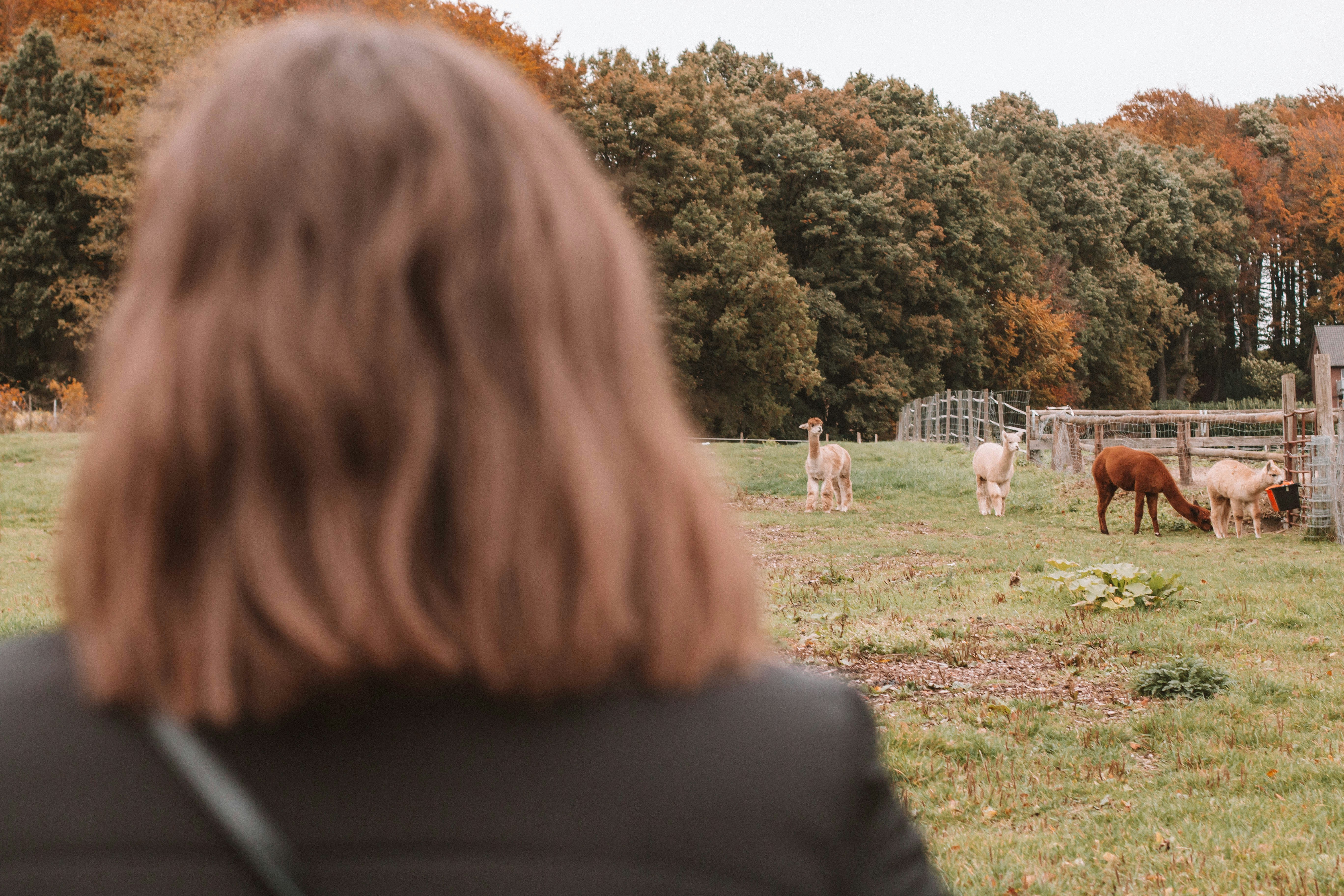 낮에 사람들 앞에 서 있는 검은 재킷을 입은 여자
