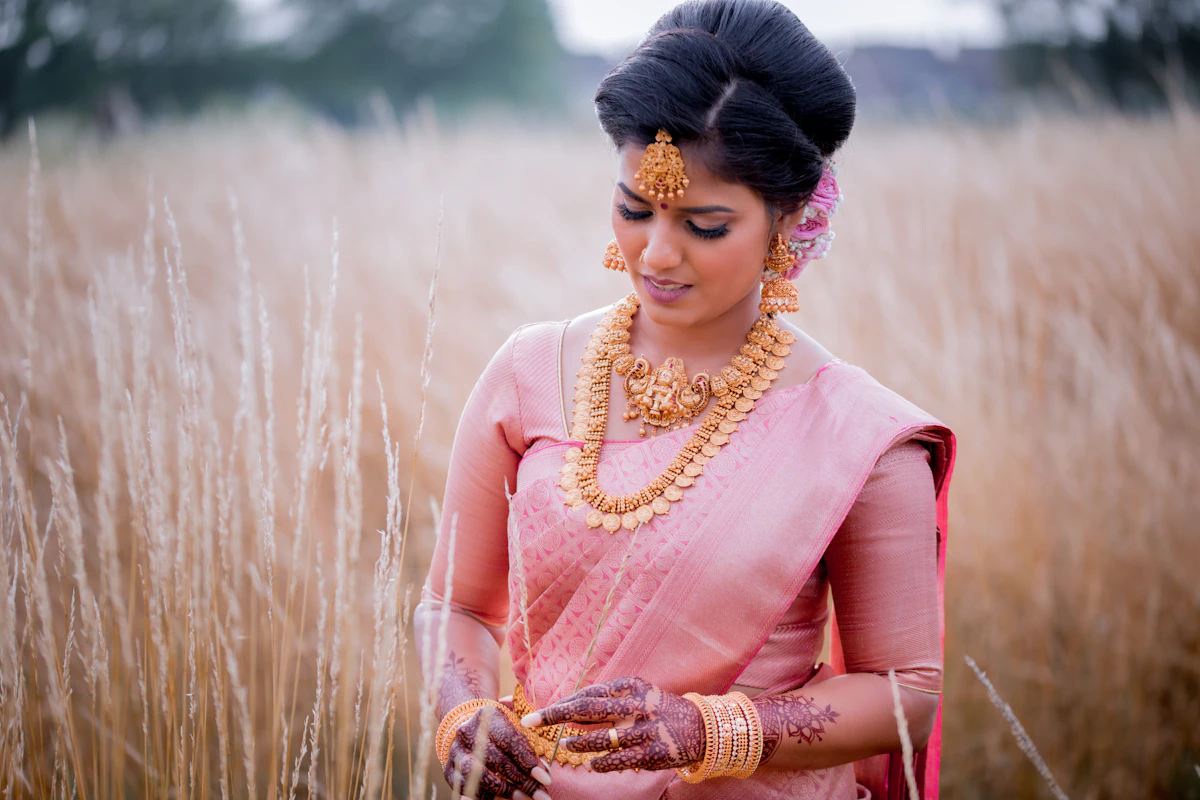 Indian bride in soft pink with gold jewelry