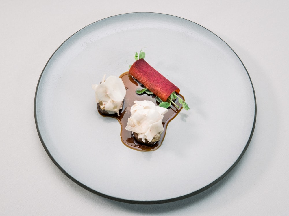 Helado blanco con hoja verde sobre plato de cerámica blanca