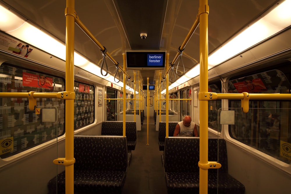 personnes assises sur un banc en bois brun à l’intérieur du train