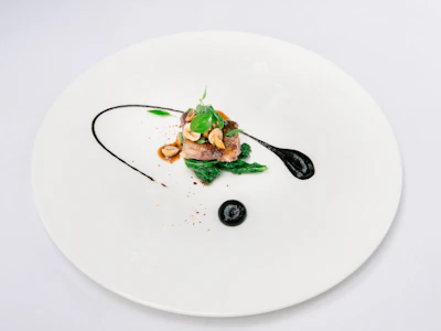 Close-up of a minimalist plate artfully arranged with fresh, vibrant ingredients against a dark backdrop.