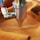 A metal nozzle attached to a blue and red tube presses against a piece of orange fabric.