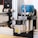 Une vue rapprochée d&#39;une machine CNC ou d&#39;une configuration de routeur équipée d&#39;un module laser. La machine dispose d&#39;un cadre métallique avec des roues pour le mouvement linéaire, tandis que le composant bleu abrite probablement un moteur ou un autre outil rotatif. Le module laser est clairement marqué d&#39;un symbole d&#39;avertissement, indiquant sa fonctionnalité.