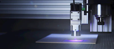 A laser cutting machine engraving a wooden promotional item with precision.