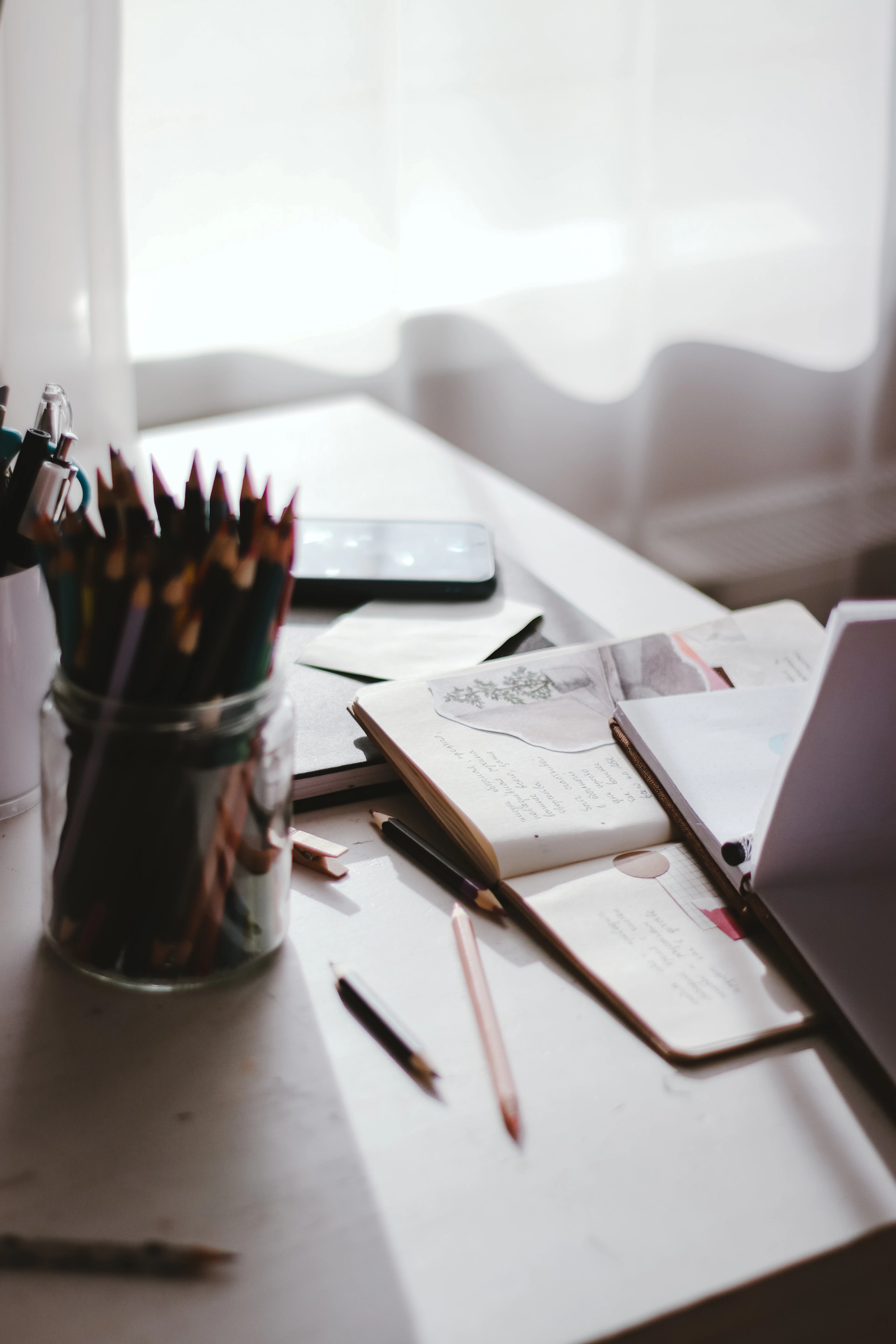 Notebook and pen arranged beside a computer for planning an author website