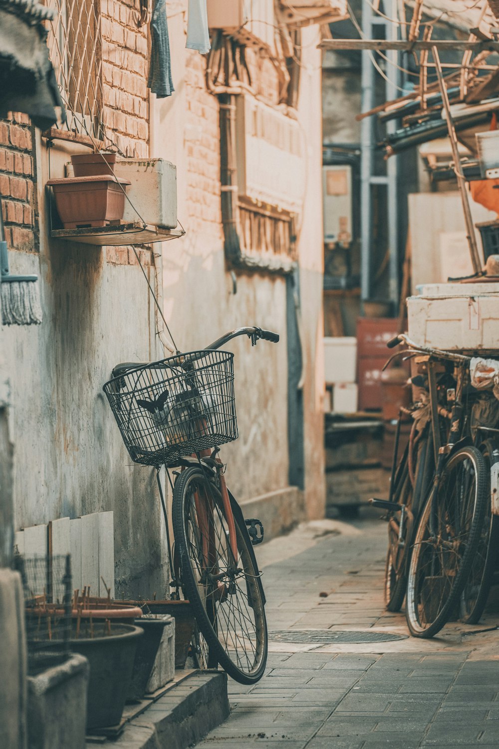 vélo de ville noir garé à côté d’un mur de béton gris pendant la journée