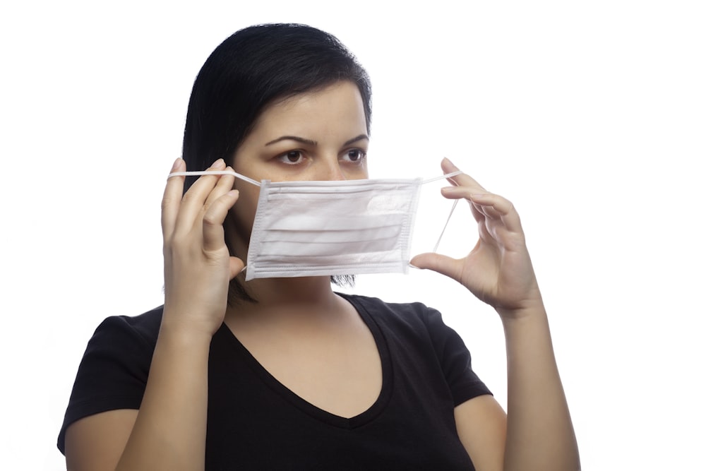 woman in black scoop neck shirt holding white paper