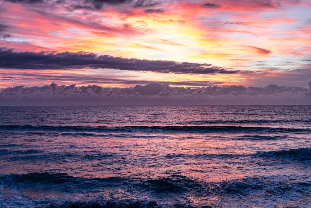 ocean waves crashing on shore during sunset