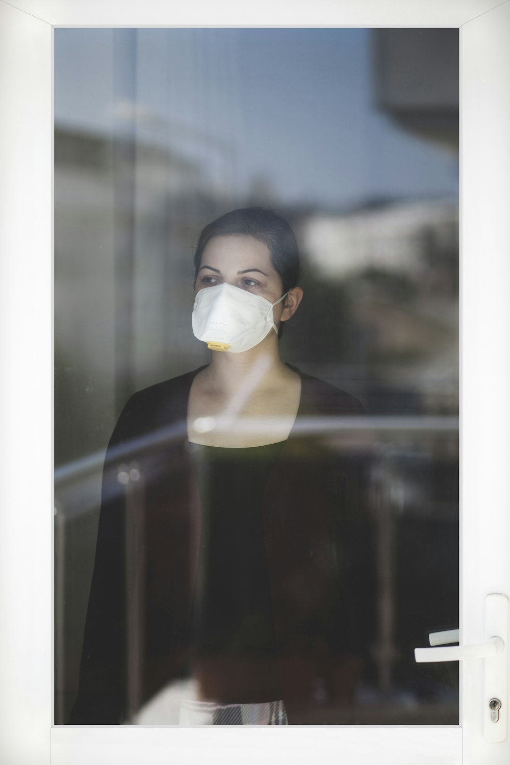 Femme en débardeur noir portant un masque facial blanc