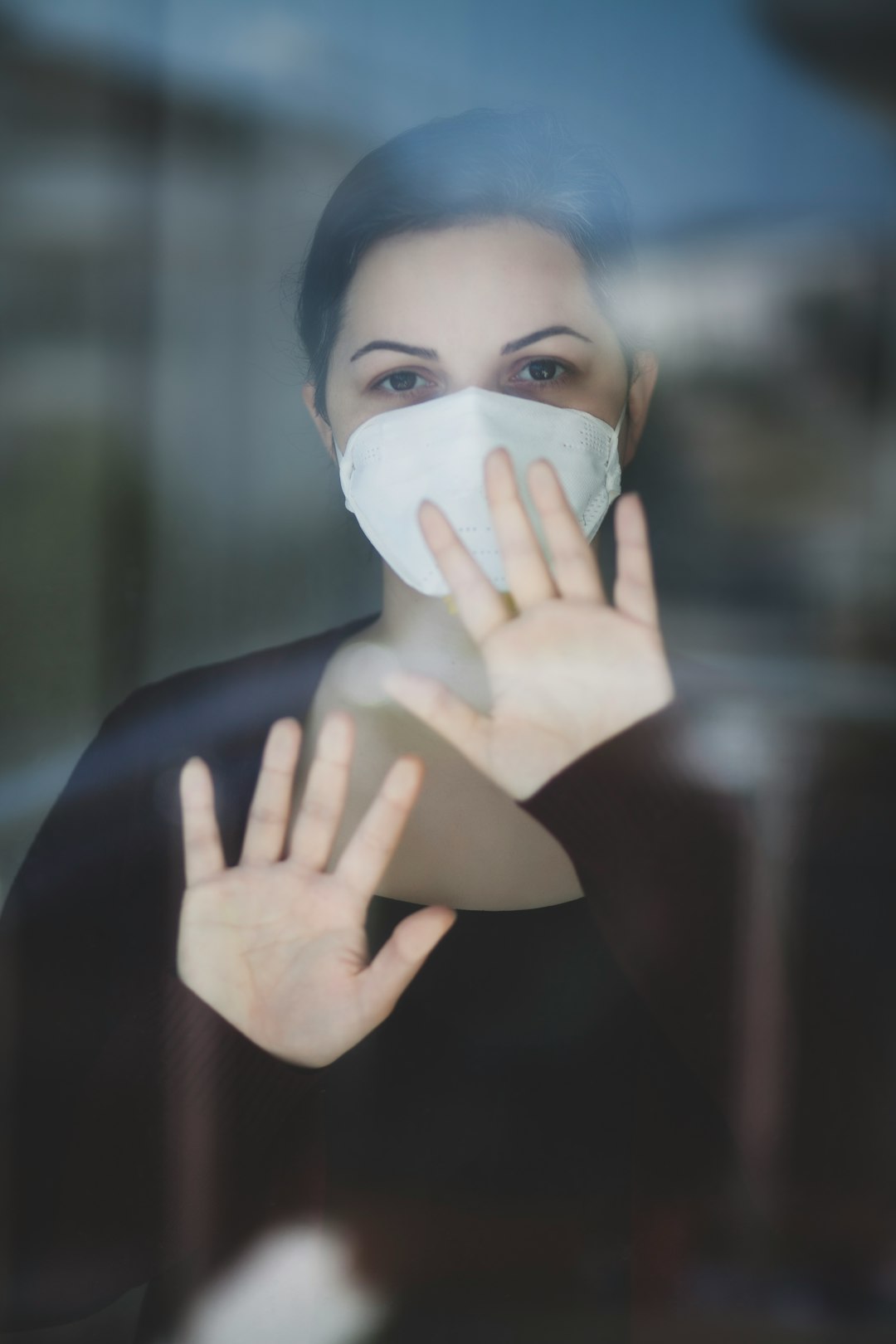 woman in black long sleeve shirt covering face with white paper