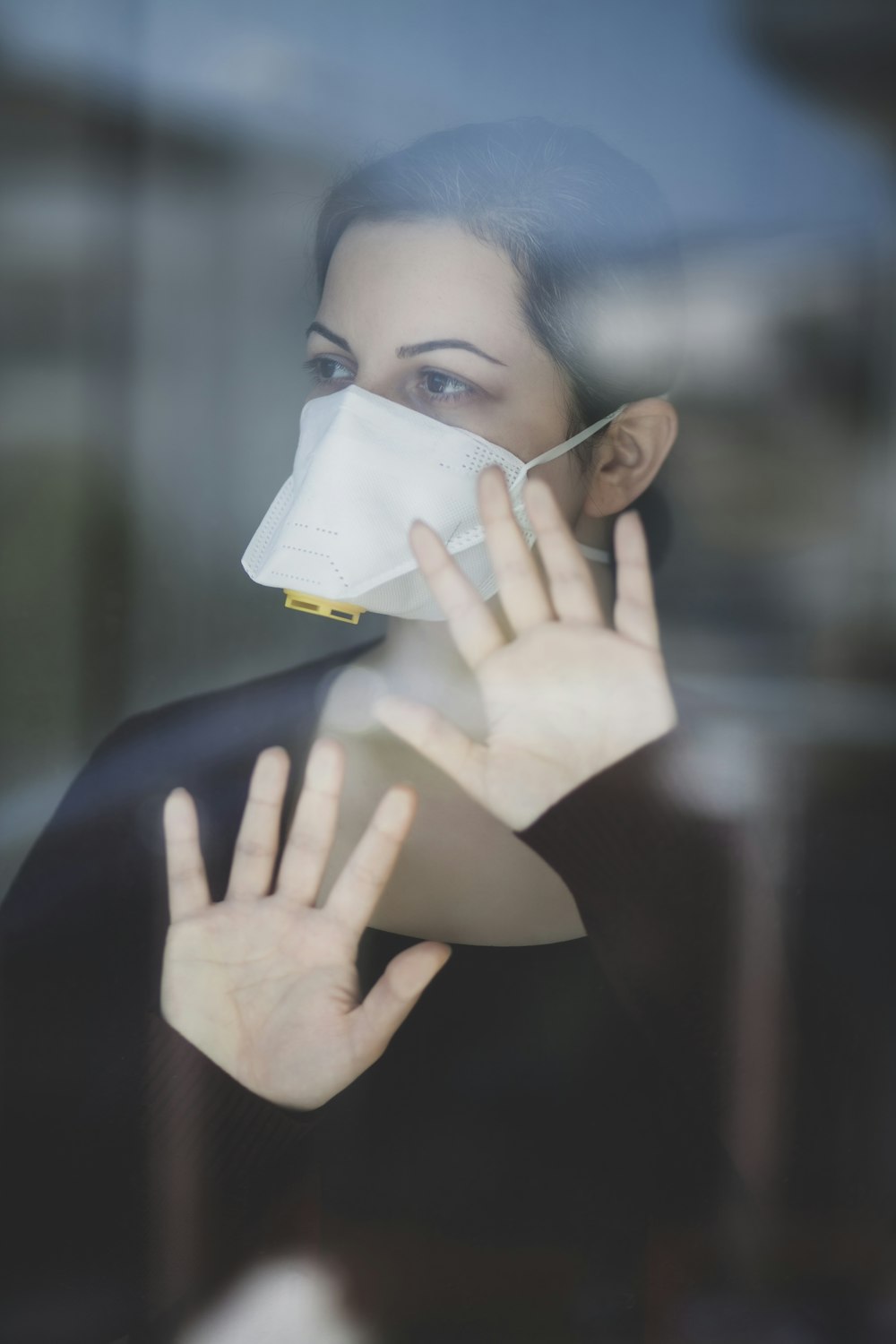 woman in black shirt covering face with white paper