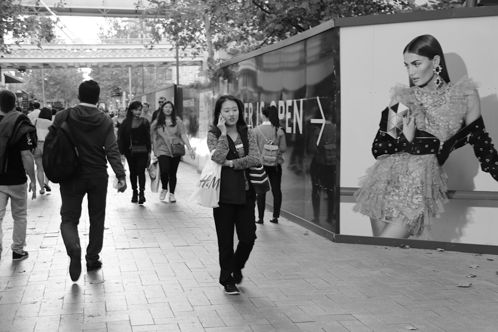 grayscale photo of people walking on sidewalk