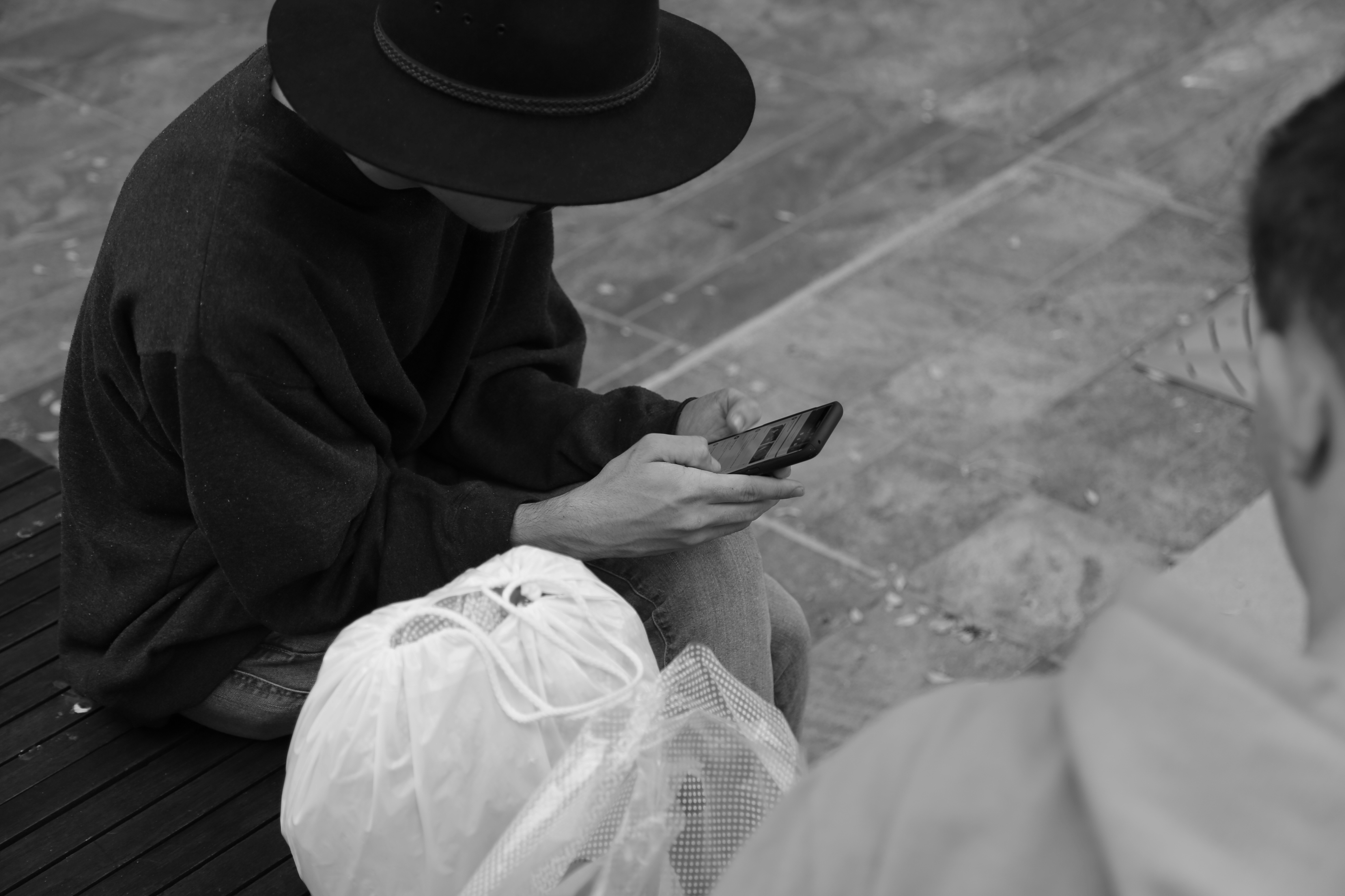 man in black hat holding smartphone