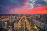 A vibrant cityscape blending purple and orange hues at dusk, symbolizing new beginnings.