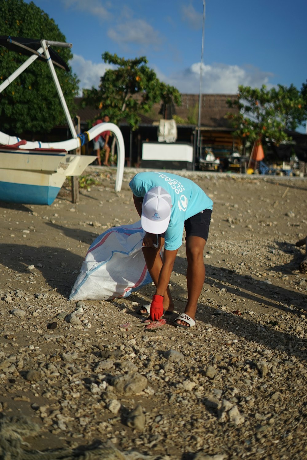 person in white t-shirt and blue shorts walking on beach during daytime