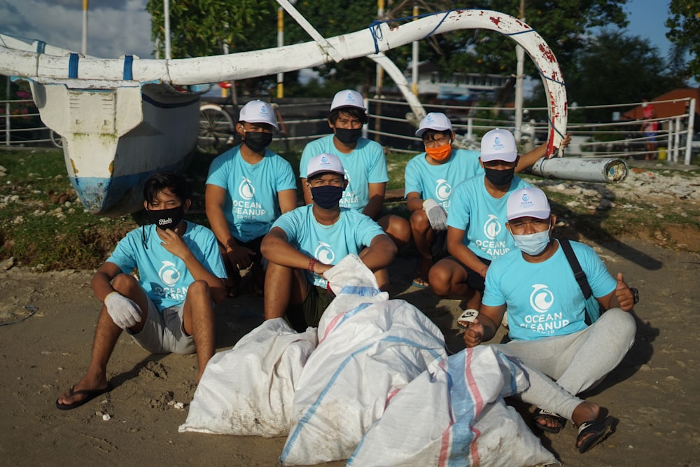 grupo de pessoas sentadas na areia marrom durante o dia