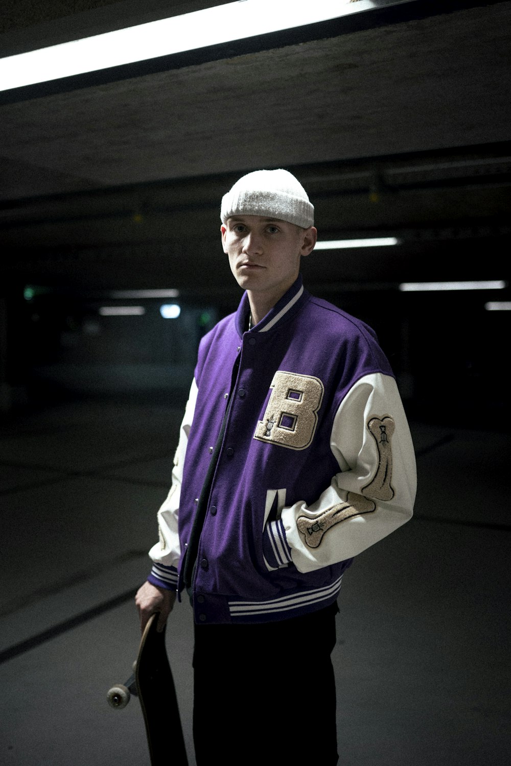 Hombre con gorra de punto blanca y chaqueta morada