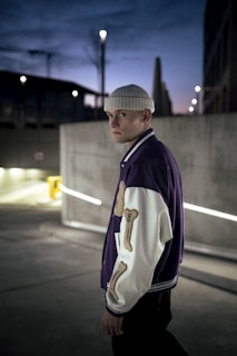 Photo of a young person wearing a sleek urban jacket walking through city streets at dusk