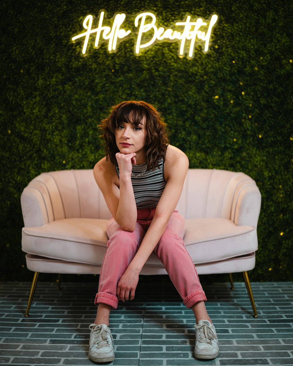 woman in black tank top and pink pants sitting on brown wooden floor