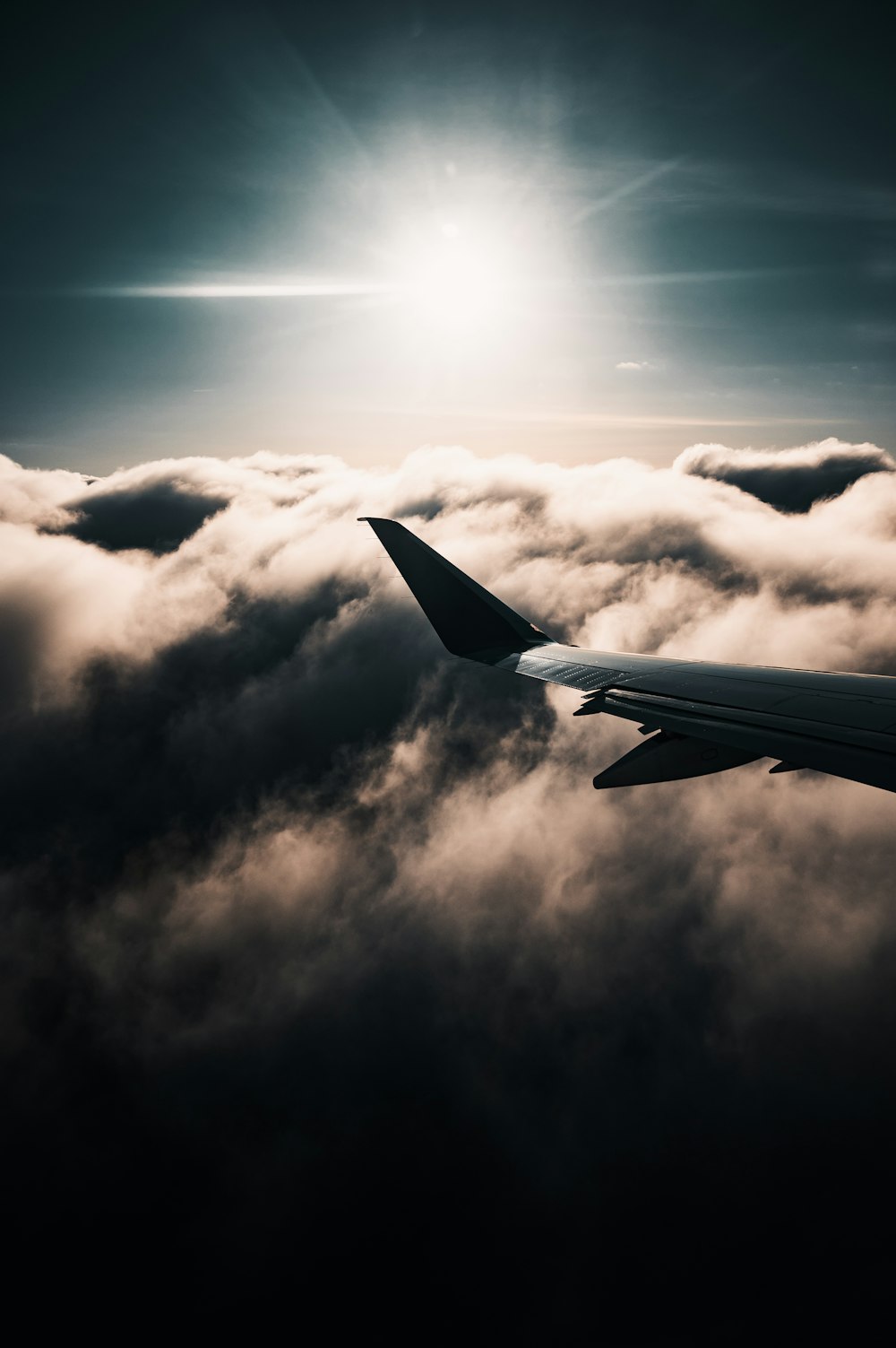 white airplane wing under white clouds during daytime