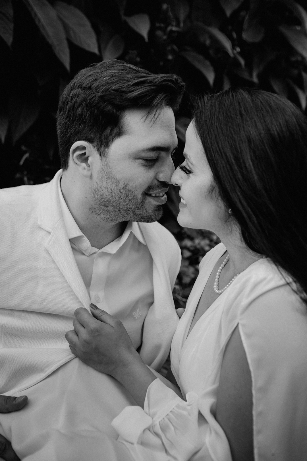 man in white dress shirt kissing woman in black dress