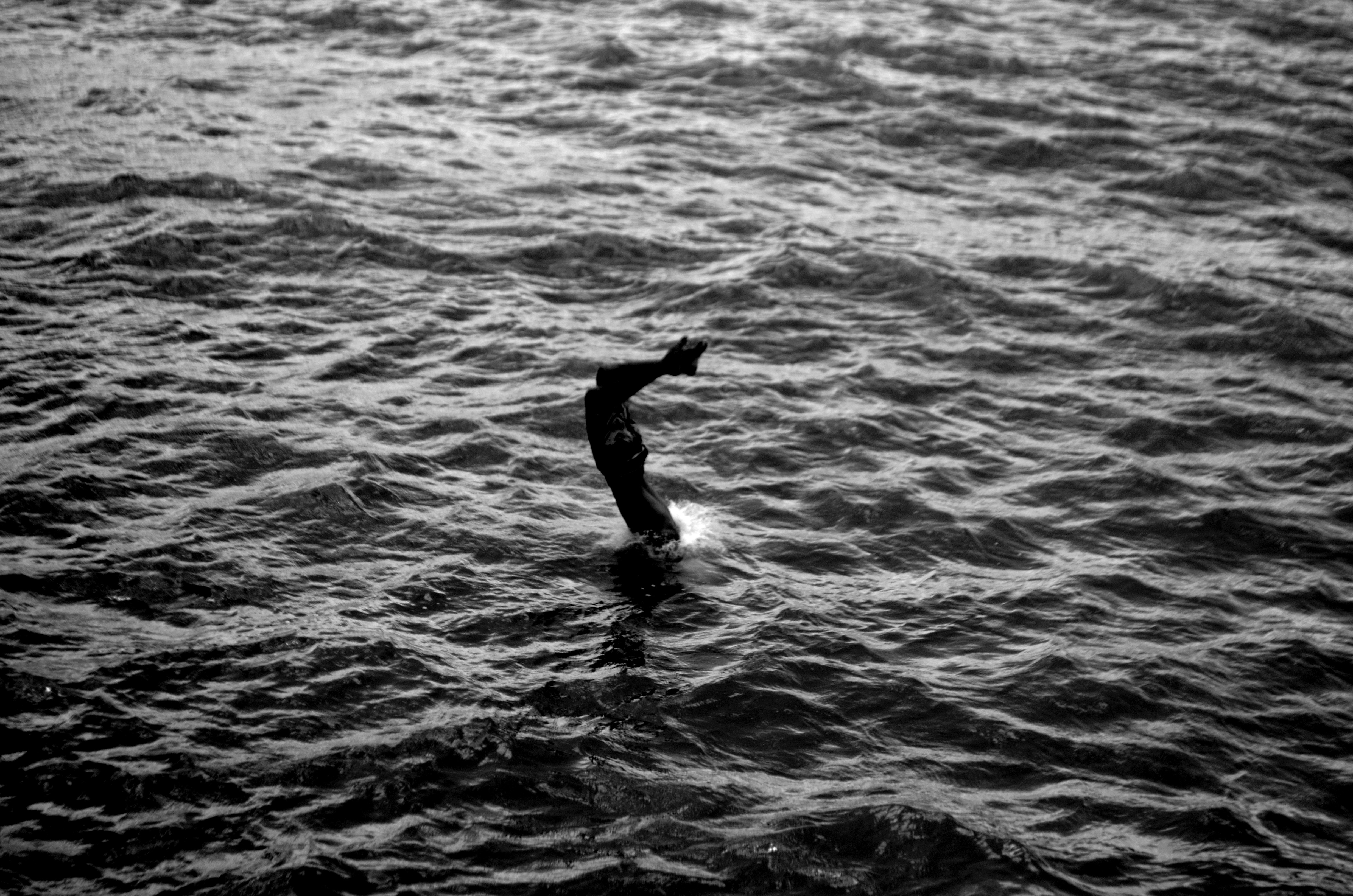 grayscale photo of man in water