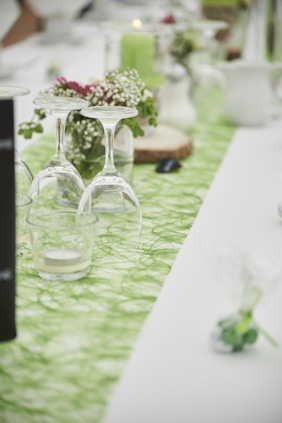 clear glass bottle beside clear glass vase on green table