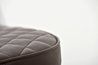 Close-up of a soft quilted cushion with intricate stitching in warm tones