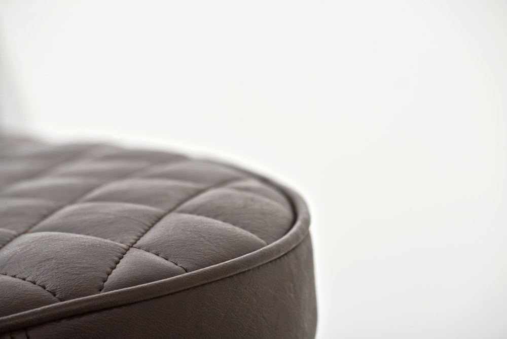 black leather round ottoman on white background