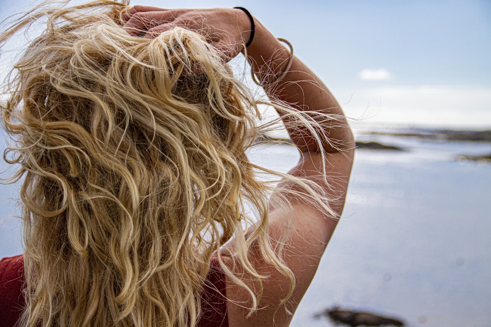 donna in occhiali da sole neri che si copre il viso con i capelli