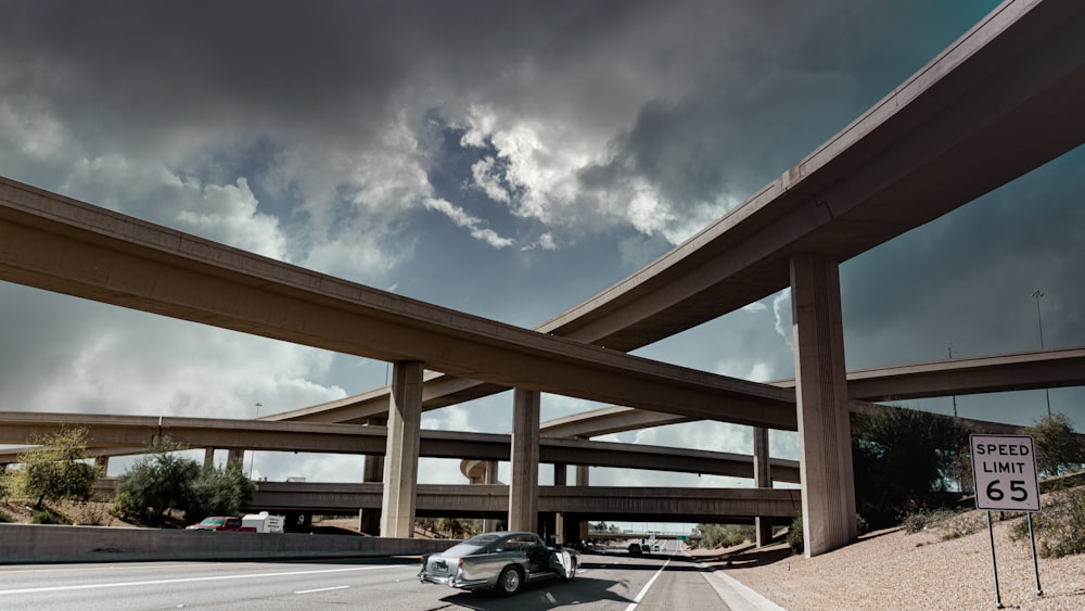 昼間の青空の下、道路を走る黒い車